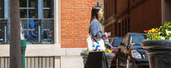 A person carrying a RISD tote bag is walking through downtown Providence.