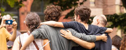 A family have their arms around each other as they have their picture taken on move-in day.