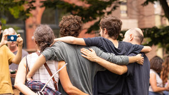 A family have their arms around each other as they have their picture taken on move-in day.